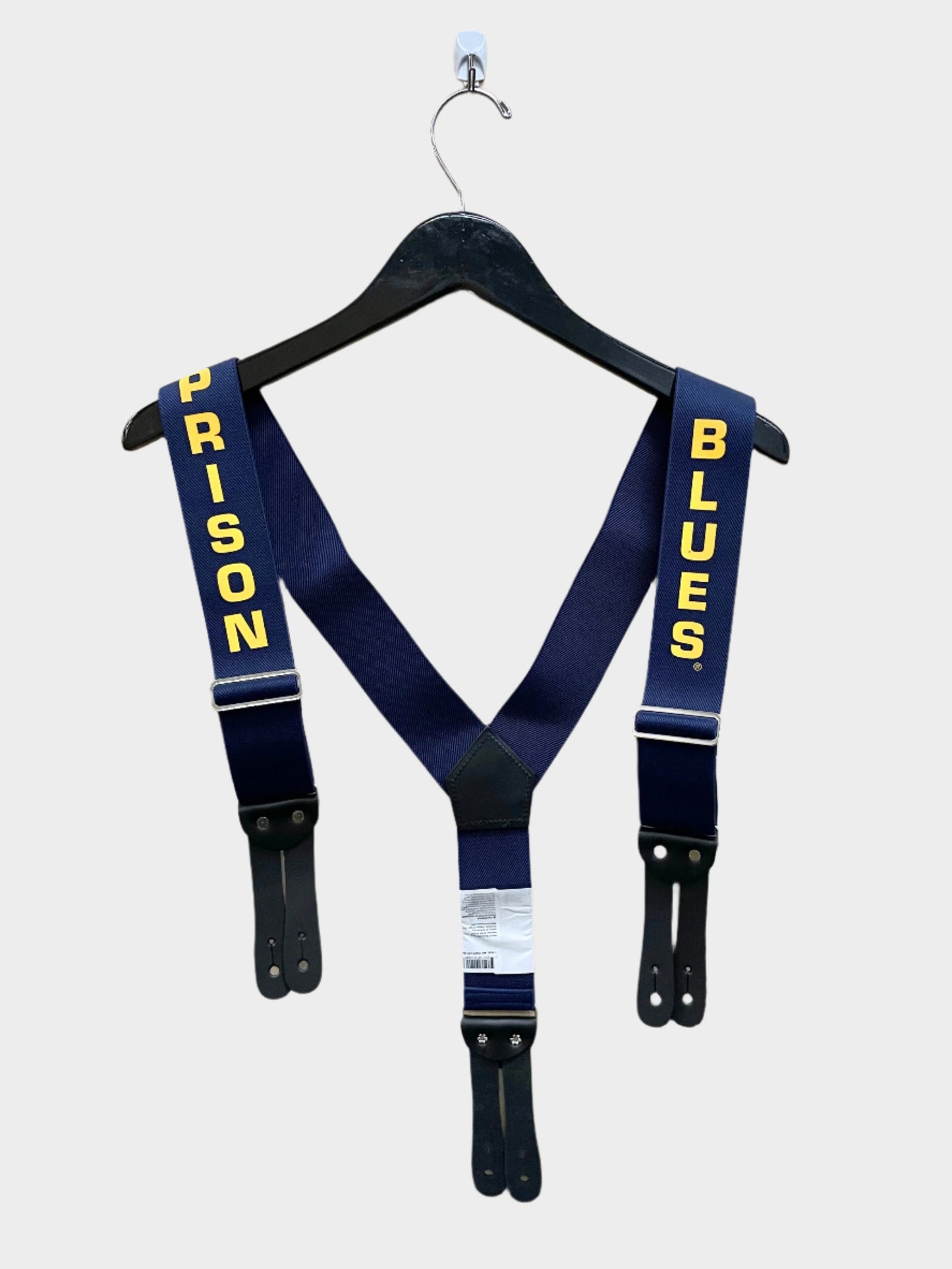 A pair of Y back navy blue work suspenders with the text 'PRISON BLUES' printed