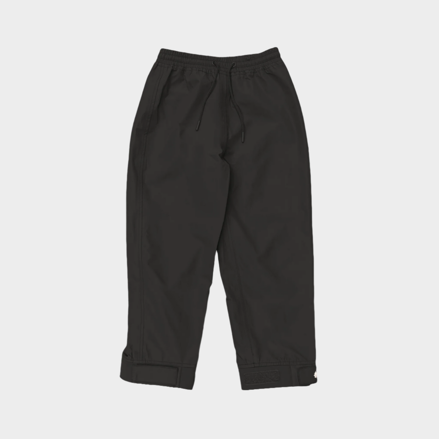 A pair of kids rain pants with an elastic waistband and drawstring. Ankles have a neoprene covered velcro adjustment. Shown in black