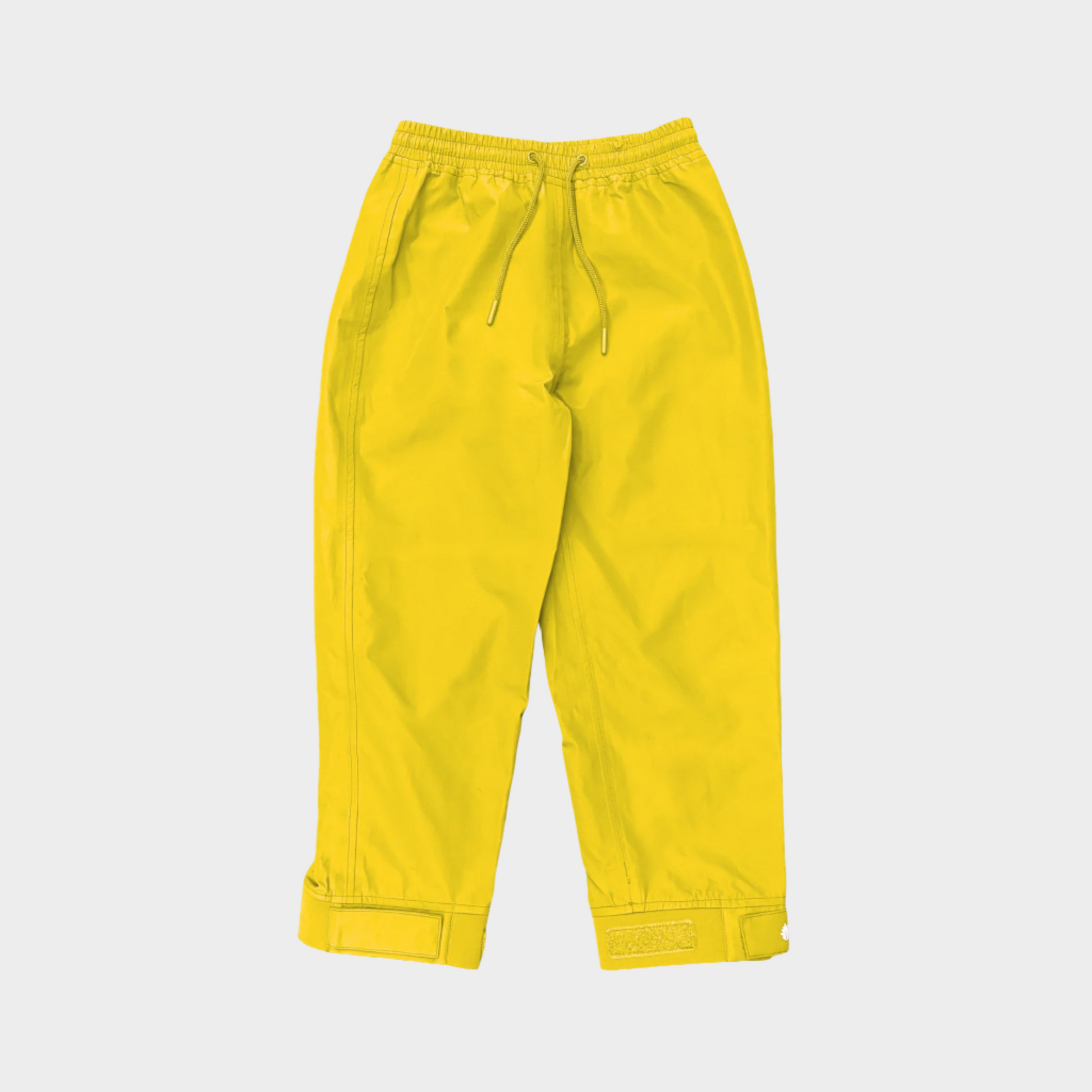 A pair of kids rain pants with an elastic waistband and drawstring. Ankles have a neoprene covered velcro adjustment. Shown in yellow