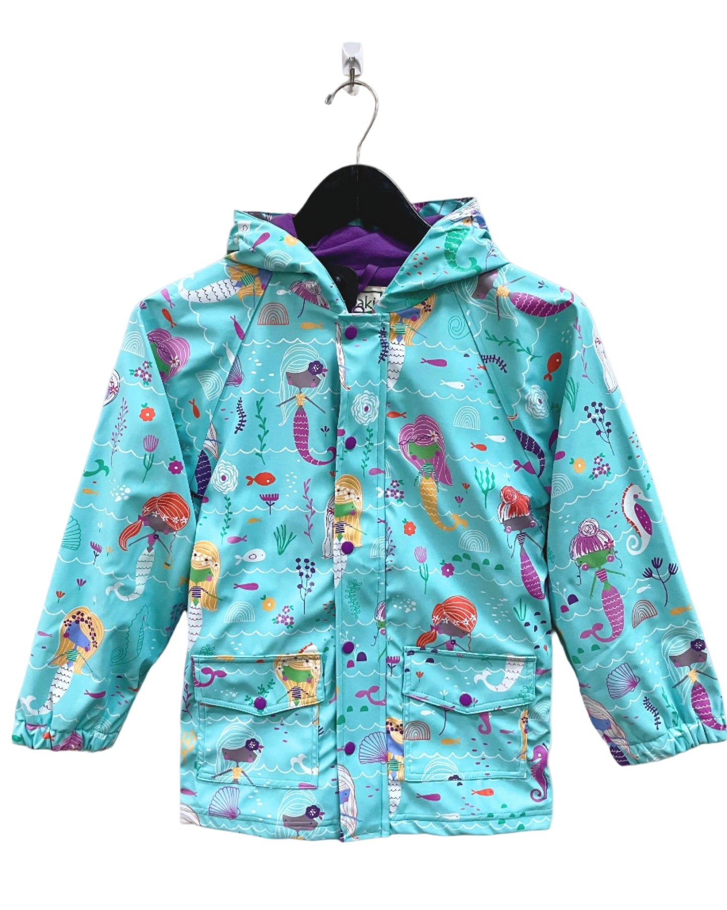 Kids lined rain coat with lining, attached hood, and pockets. Shown in mermaids pattern with a brought blue background