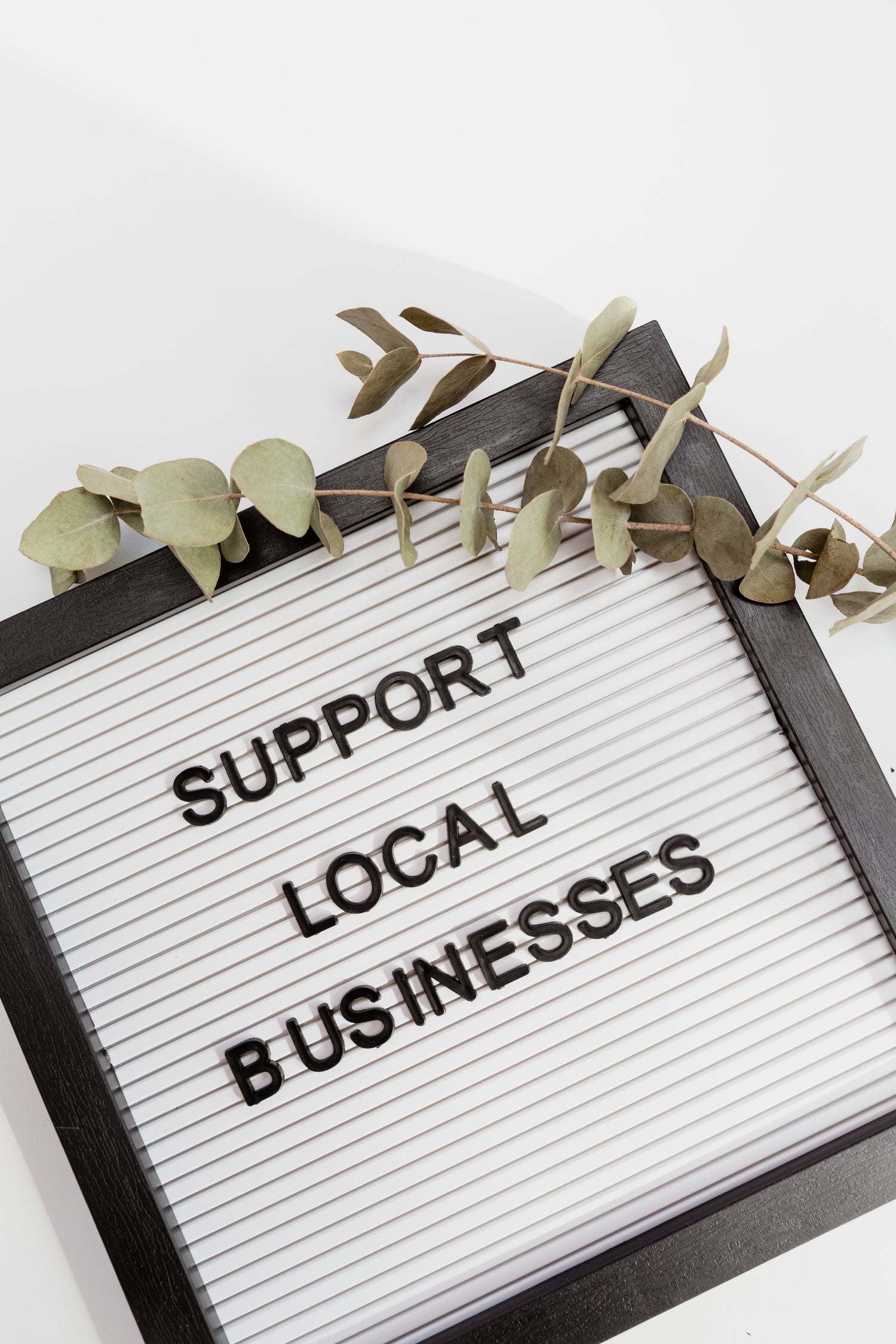 Stock image of with Support Local Businesses in a frame with plant