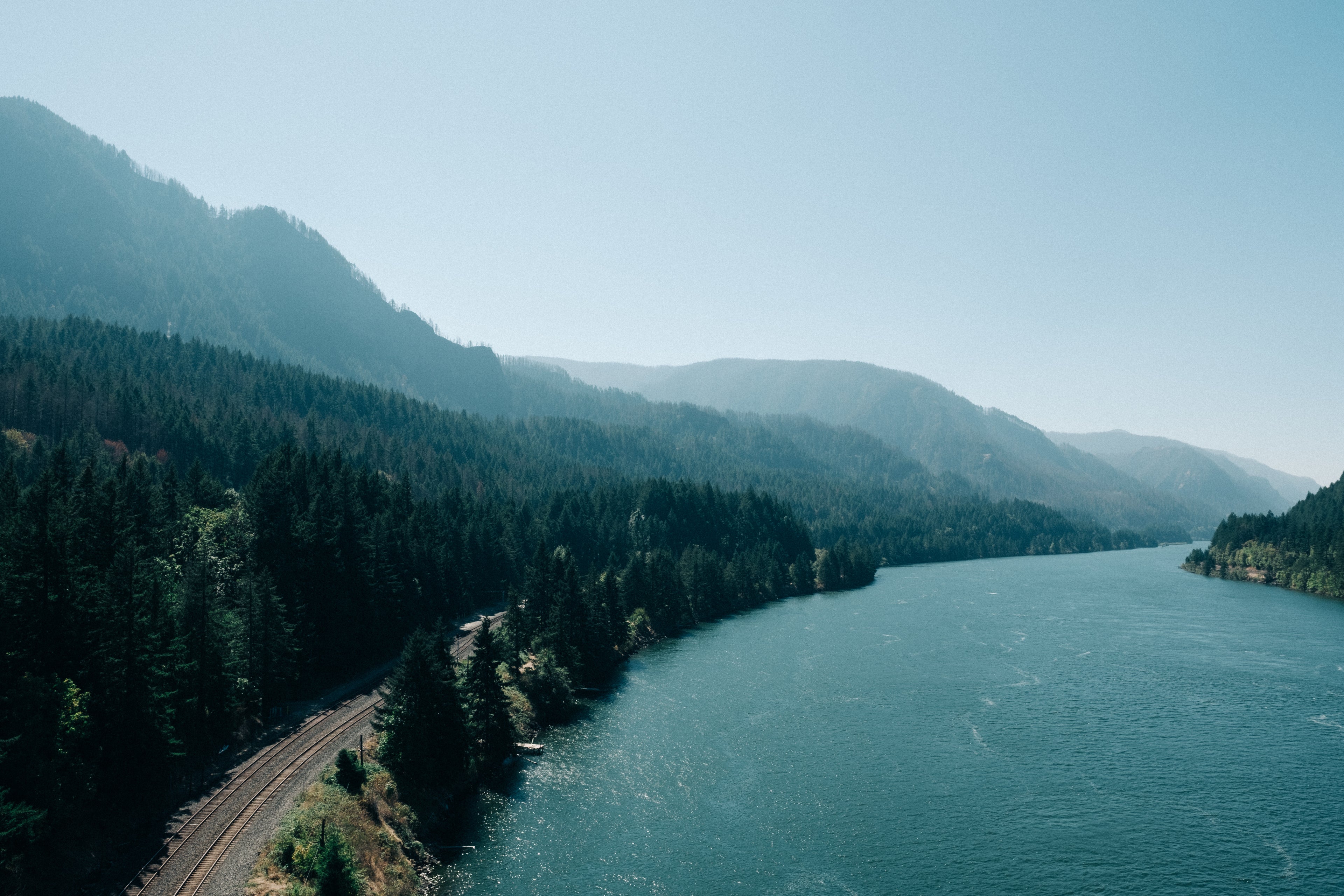 Stock image of forest lined mountain and water